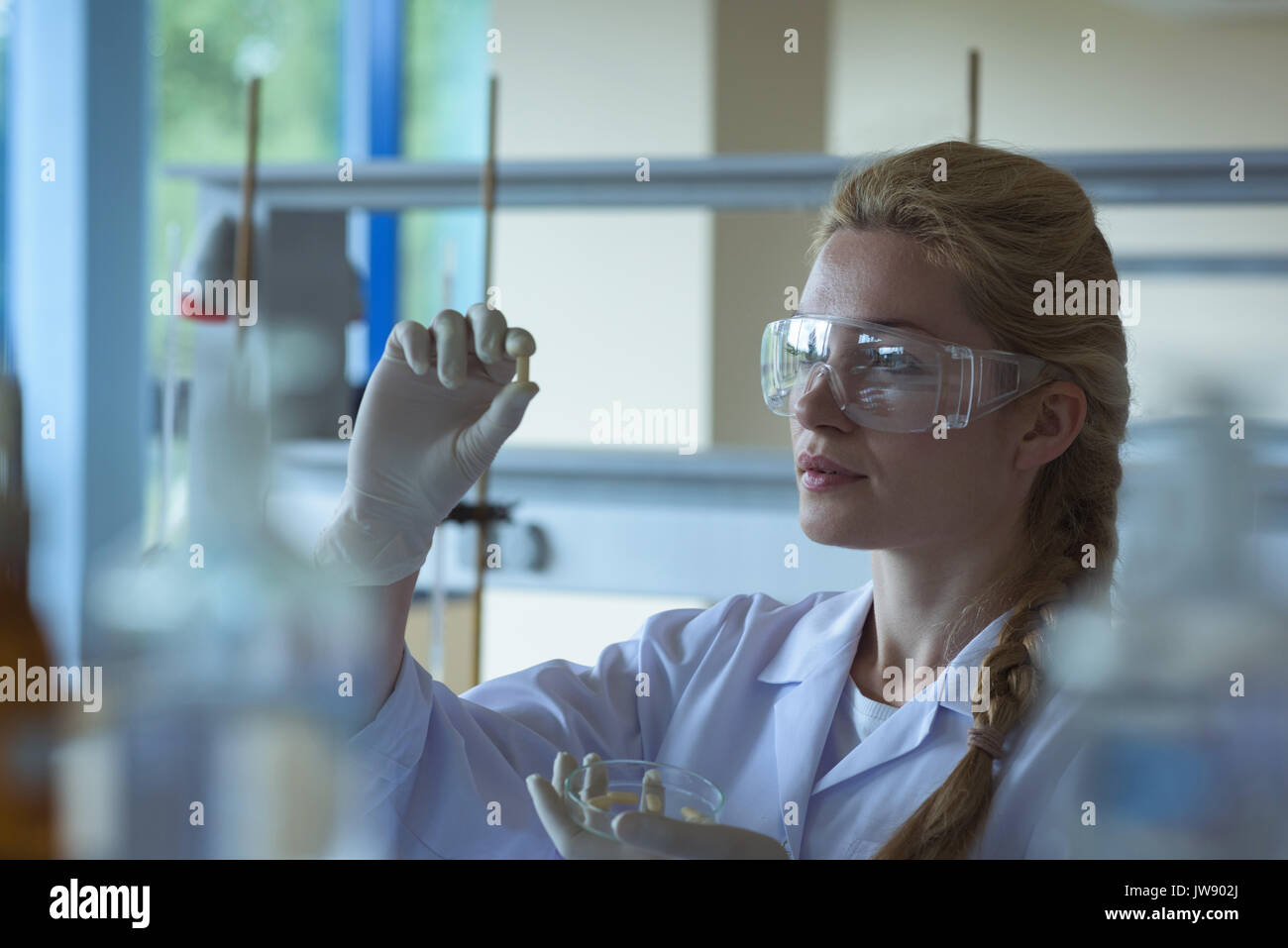 Attentive university student doing a experiment in laboratory Stock Photo