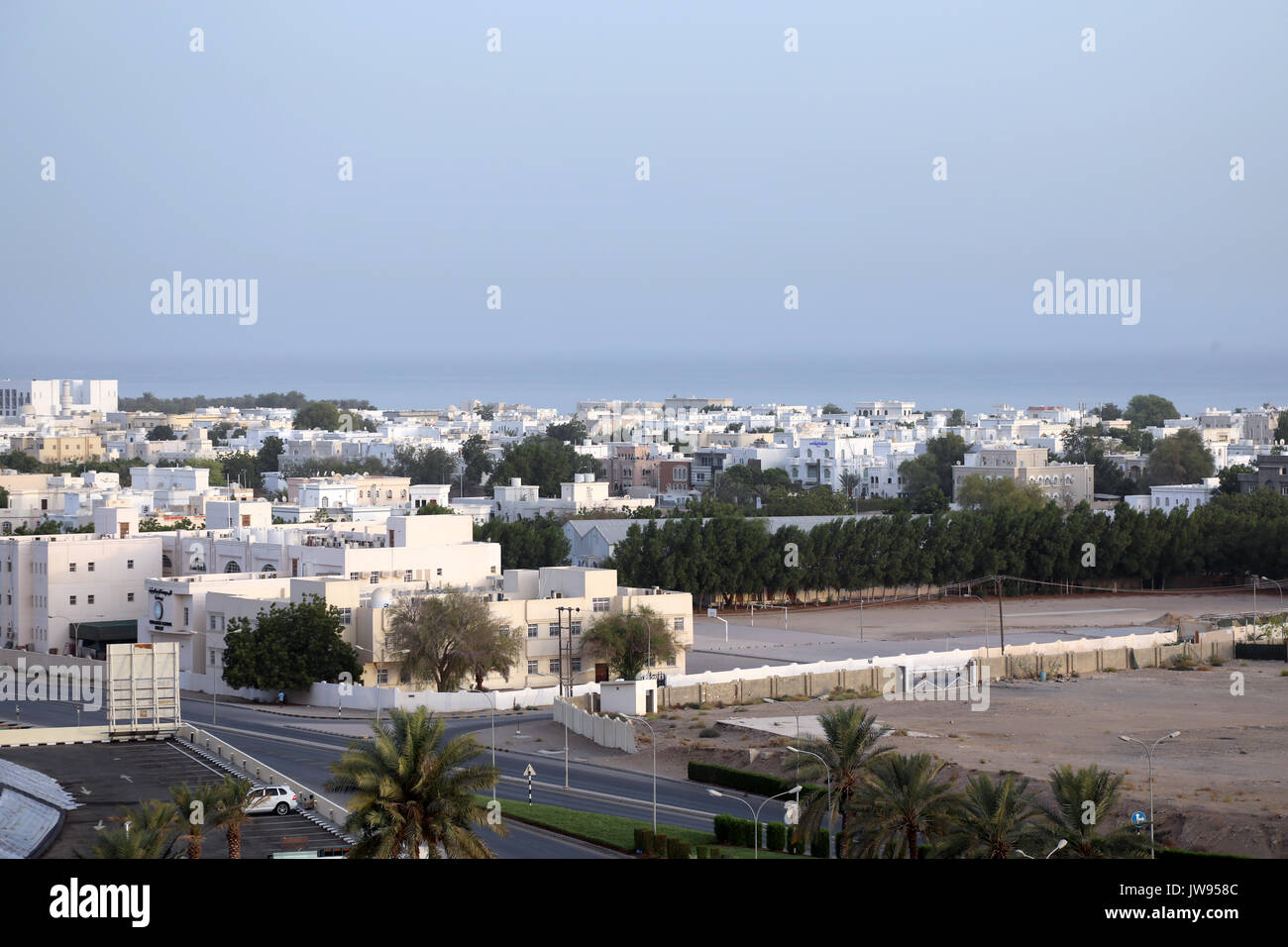 The white-washed low-rise homes, offices and other buildings of the Al Ghubra area of the Omani capital, Muscat on 8 August 2017 Stock Photo