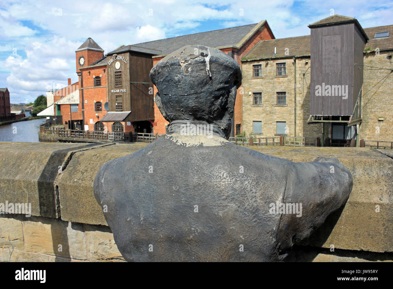 Sculpture of a Canal Boat Worker or 'Bargee' overlooking the Leeds & Liverpool canal at Wigan Pier Stock Photo
