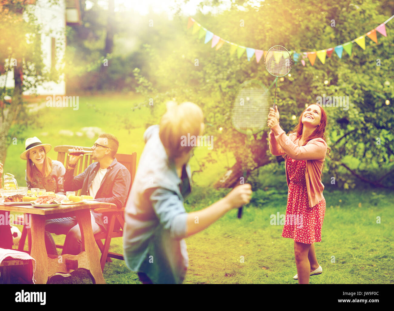 happy friends playing badminton at summer garden Stock Photo