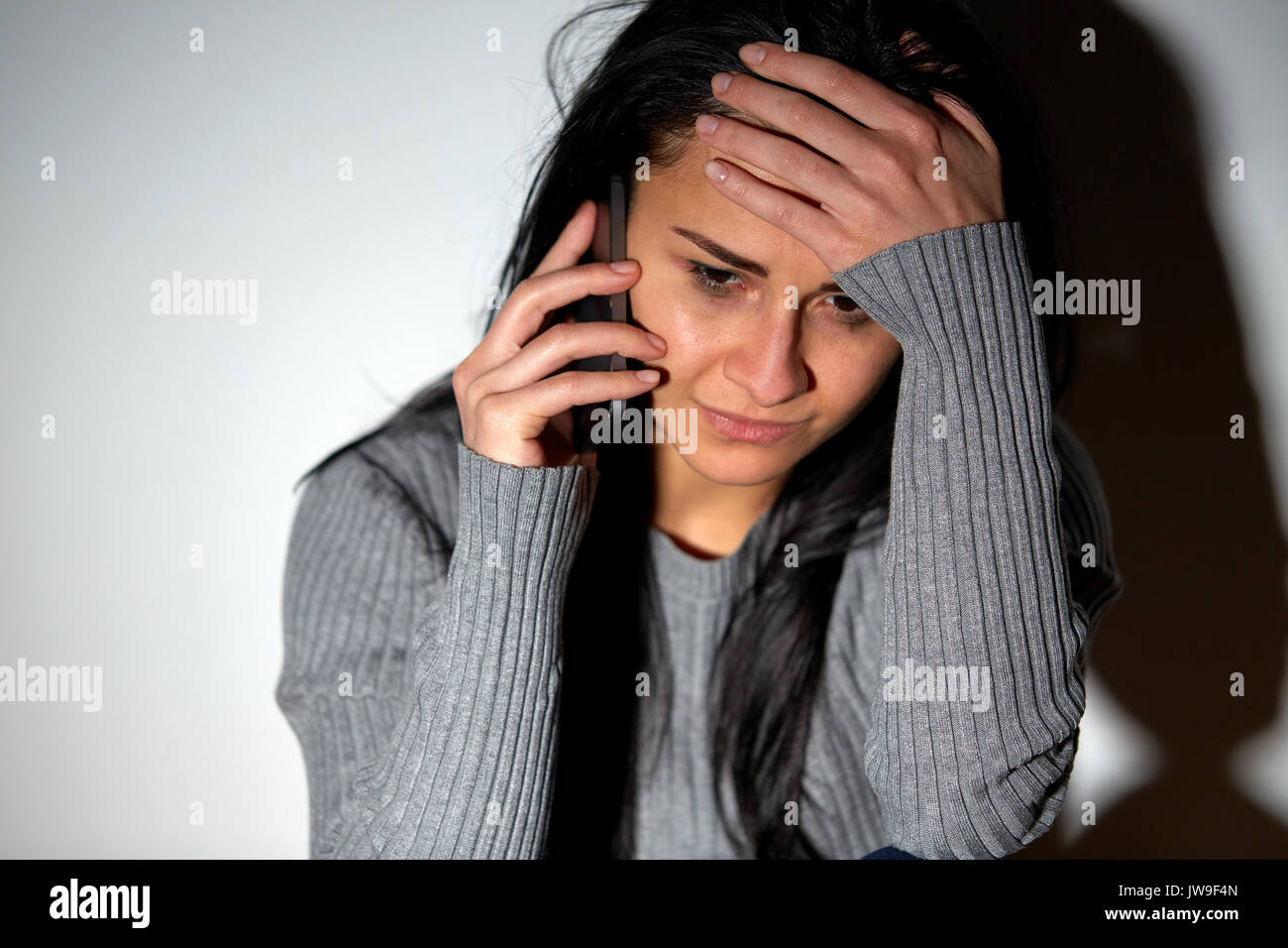 close up of crying woman calling on smartphone Stock Photo