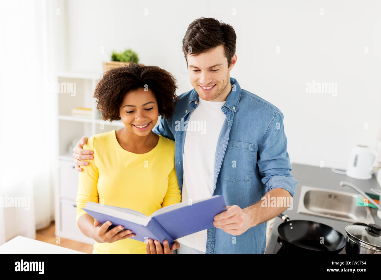 happy couple with cooking book at home kitchen Stock Photo