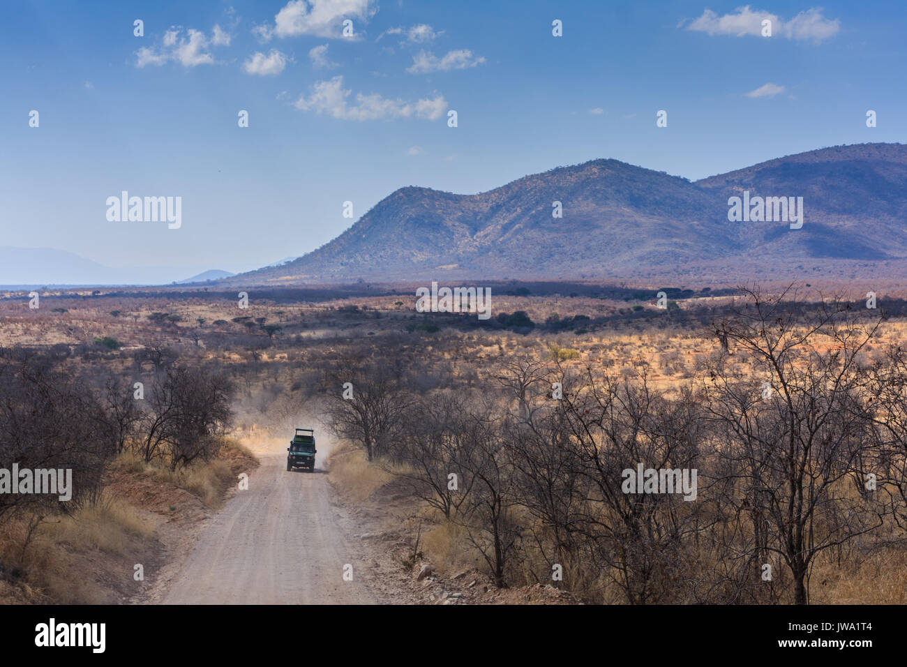 Game vehicle drives tourists in Ruaha National Park, Tanzania Stock Photo