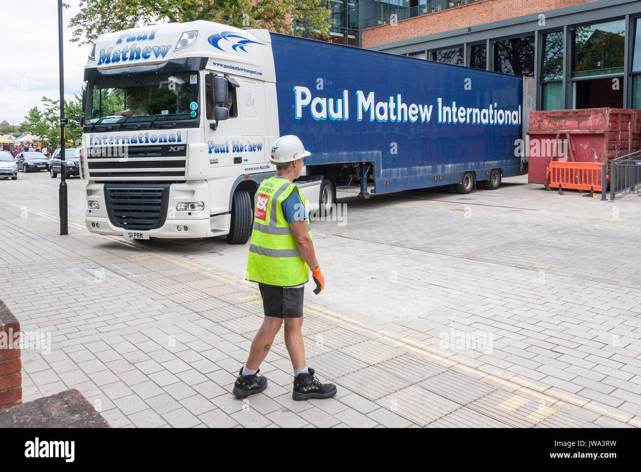 Banksman directs HGV into parking area at theatre stage door Stock Photo