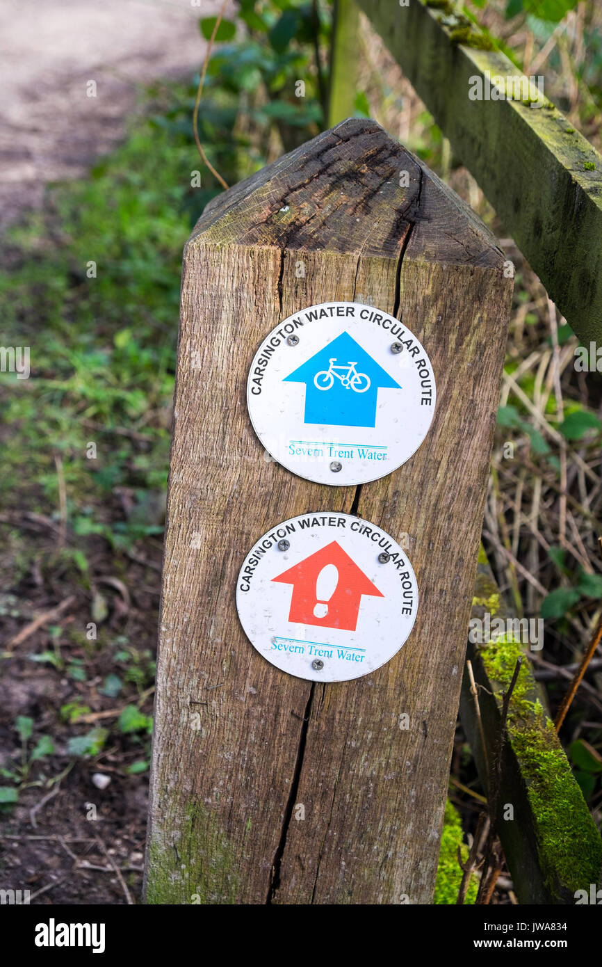 A wooden sign post with arrows for the cycling and walking circular routes at Carsington Water or Reservoir, Carsington, Derbyshire, England, UK Stock Photo