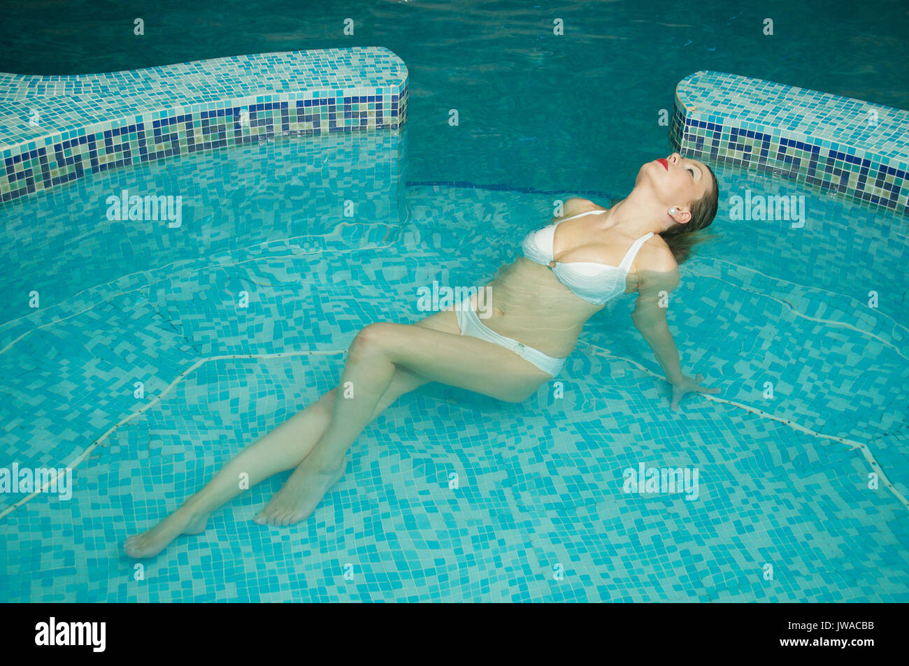 Beautiful girl wearing a white bikini in an indoor swimming pool Stock  Photo - Alamy