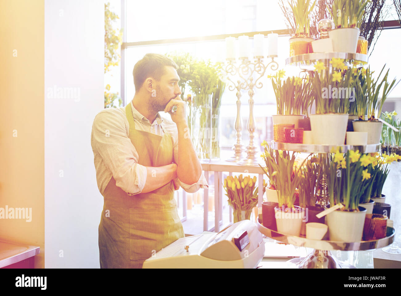 sad florist man or seller at flower shop counter Stock Photo