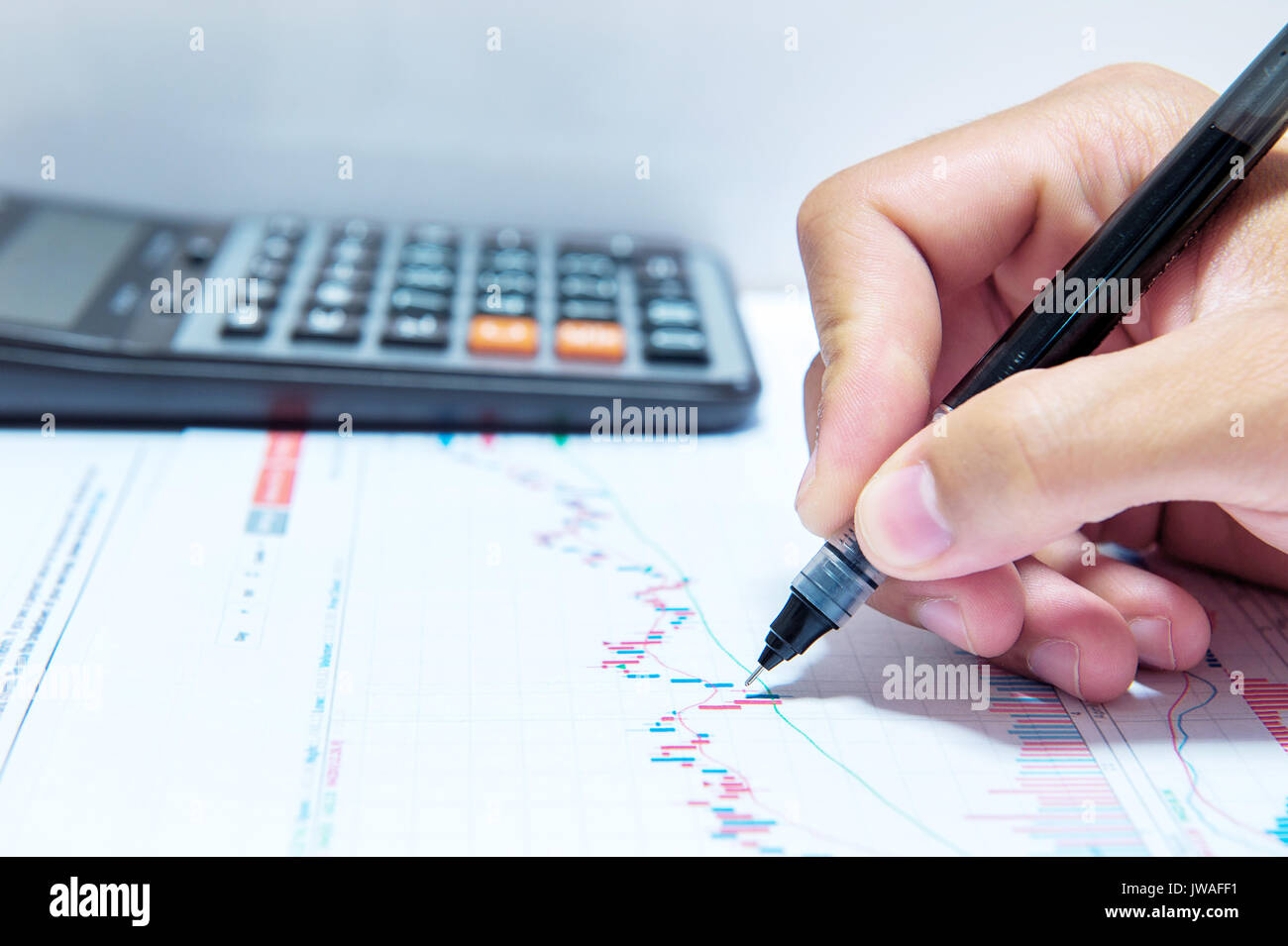 Businessman hand holding a pen working on document. Stock Photo