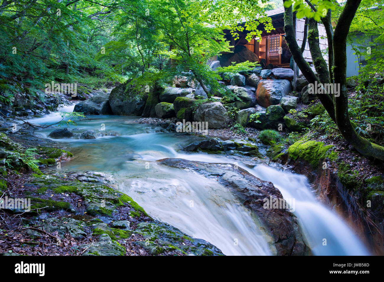 A natural waterfall and outdoor baths at Misatokan Ryokan in the Nakanojo district in Gunma, Japan Stock Photo