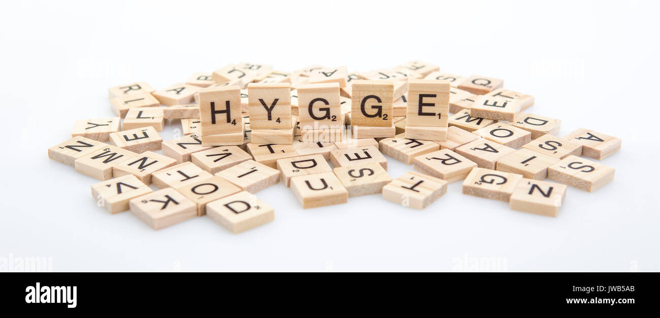 HYGGE  spelt on word tiles on a white background, Hygge is a Danish and Norwegian word which can be described as a quality of cosiness and comfortable Stock Photo