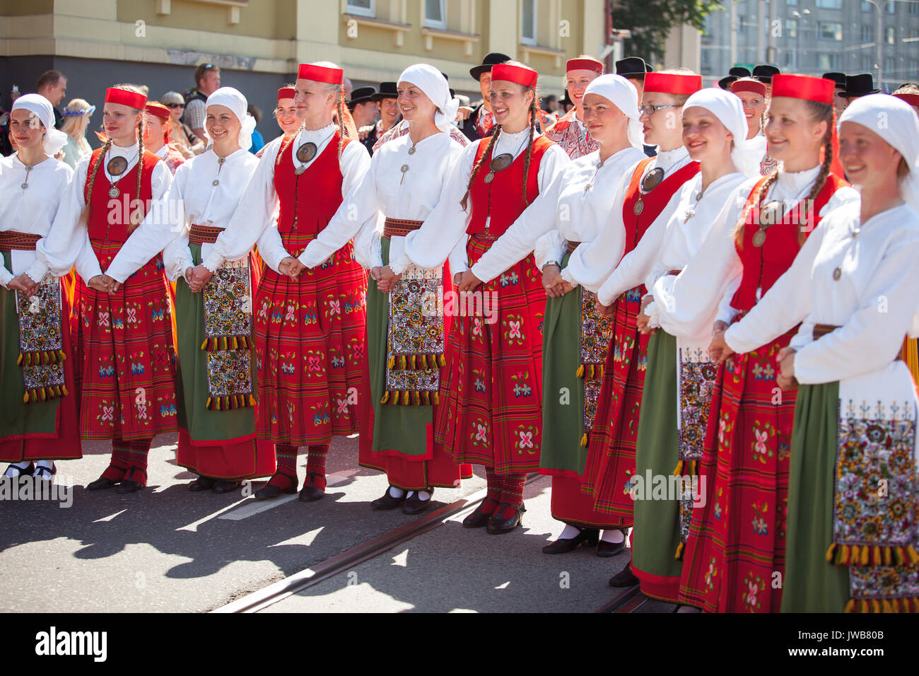 TALLINN, ESTONIA - 04 JUL 2014: People in Estonian costumes going at ceremonial procession of Estonian song and dance festival Stock Photo