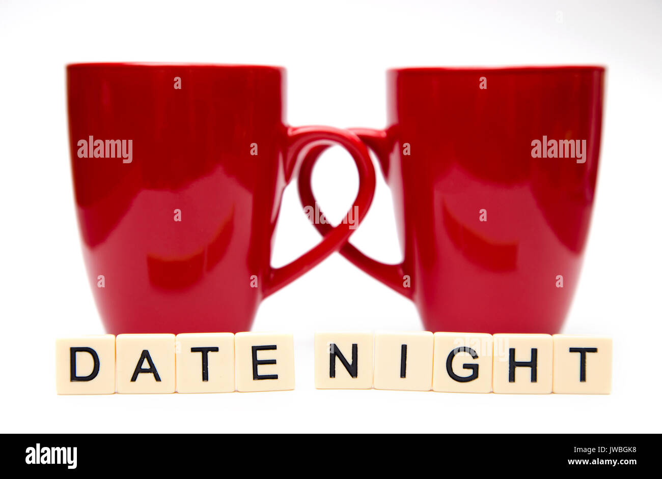 Date Night Spelled out in Tiles with Two Coffee Mugs Stock Photo