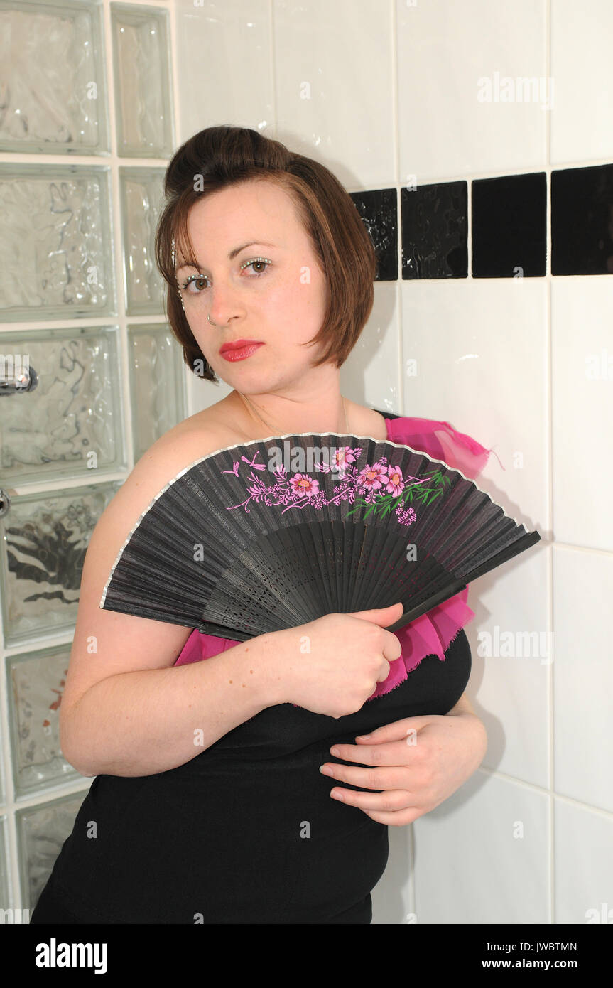 Pretty girl having fun in the shower fully dressed Stock Photo