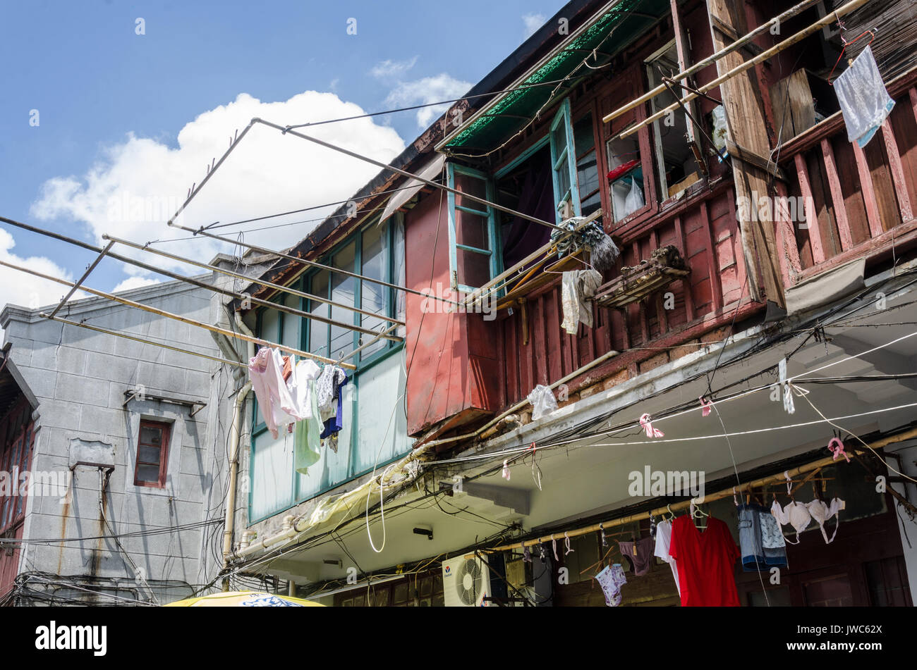 Clothes drying racks overhang the street from first floor windows down a  street in Shanghai, China Stock Photo - Alamy