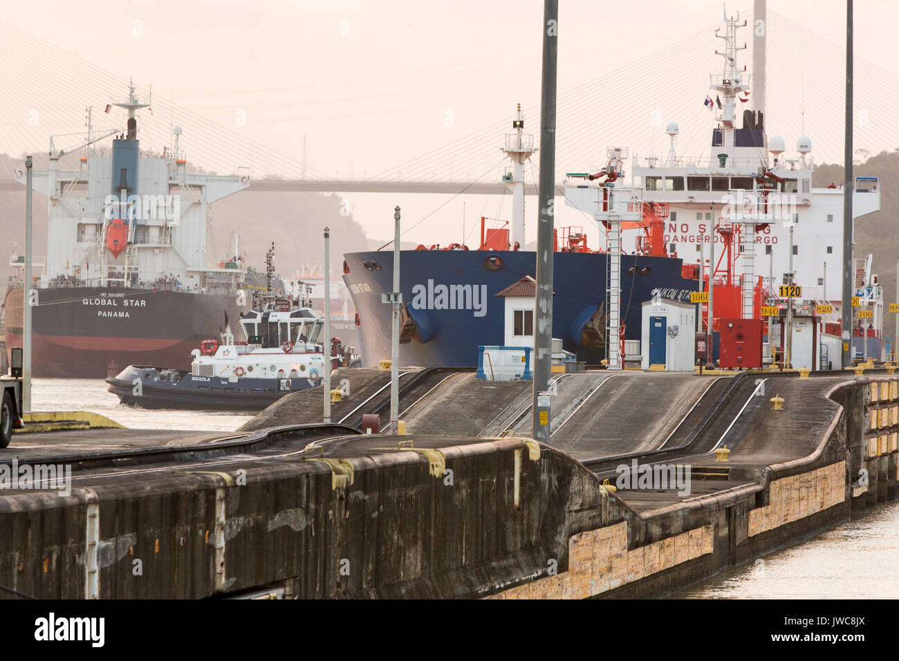 At Pedro Miguel Locks,near the Centennial Bridge,large shipping vessels and tugboats are stationed along the Panama Canal. Stock Photo