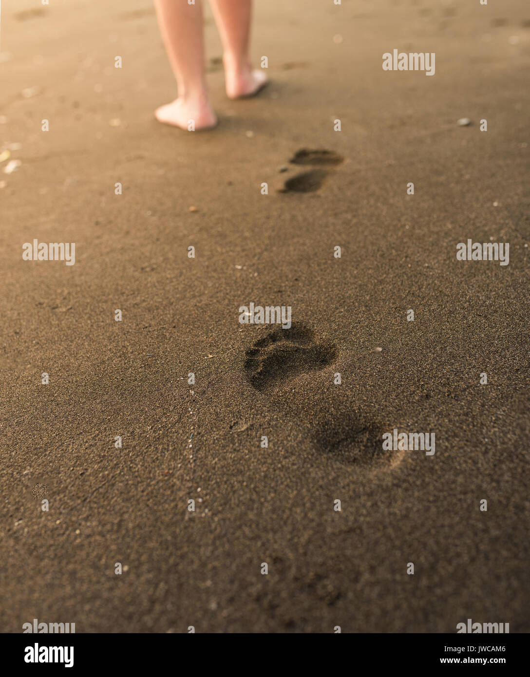 Woman walking on sand beach leaving footprints in the sand. Close Up ...