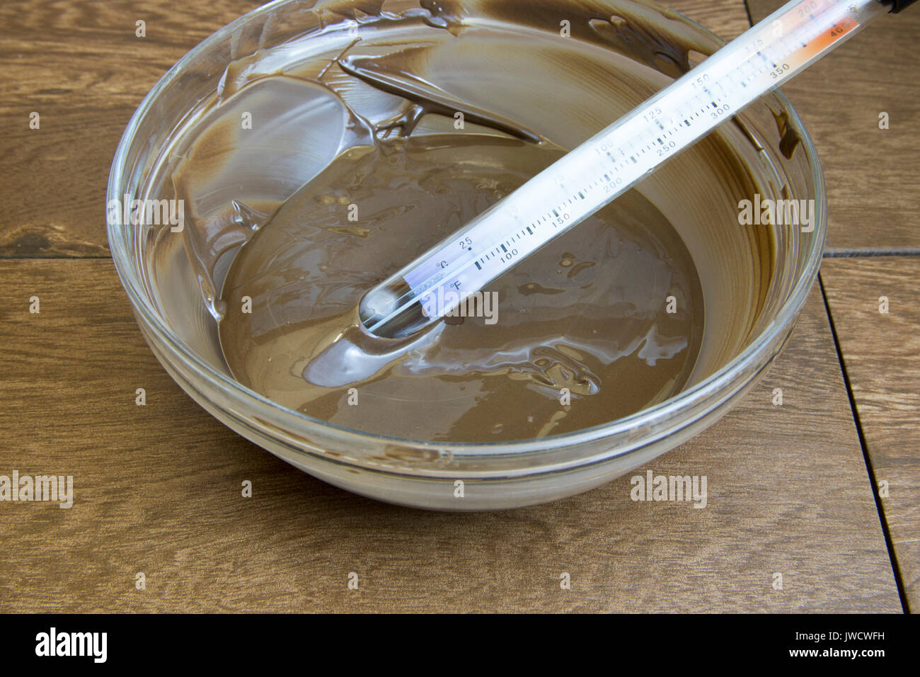 https://c8.alamy.com/comp/JWCWFH/glass-bowl-full-of-tempered-dark-chocolate-with-candy-thermometer-JWCWFH.jpg