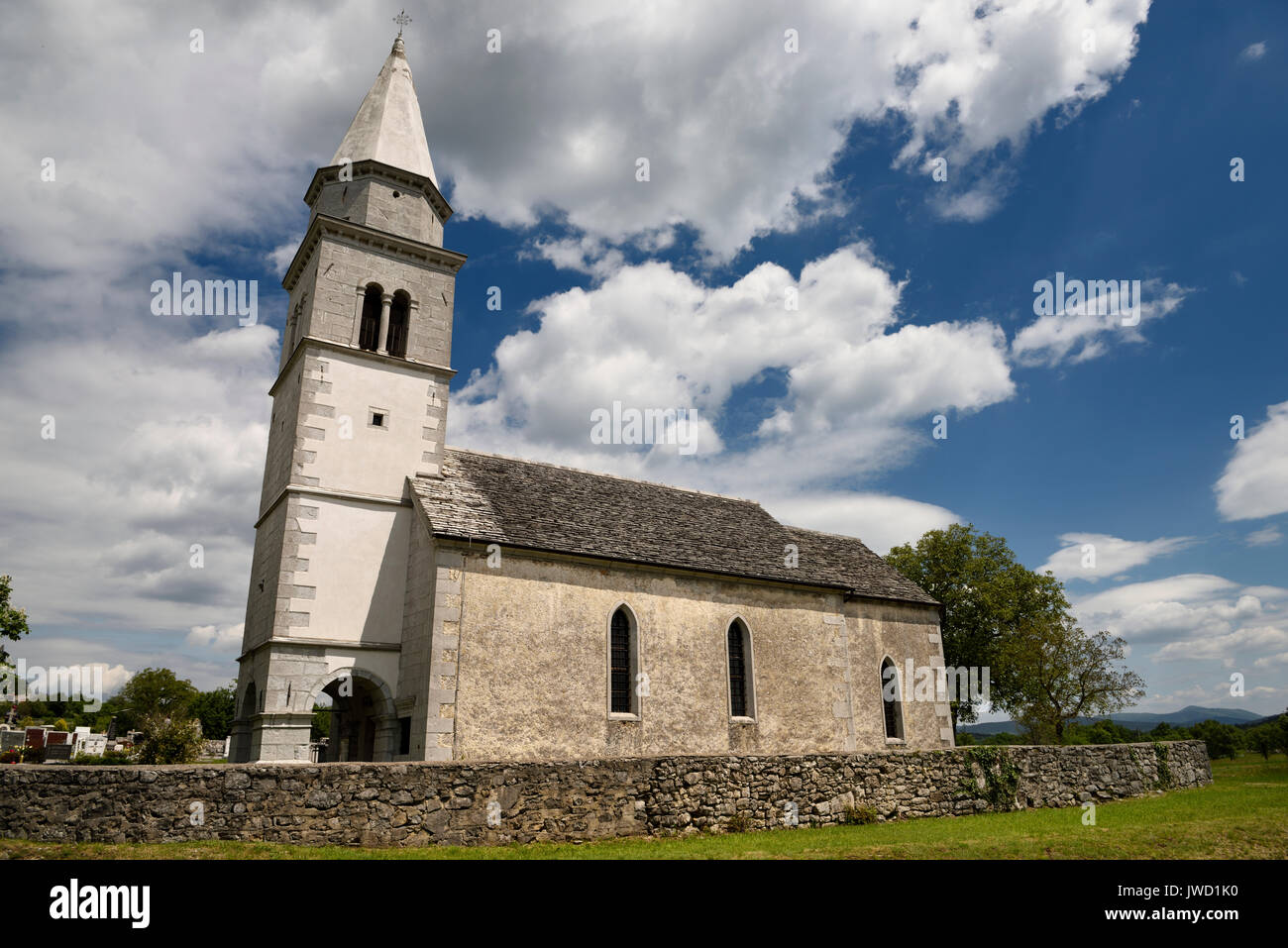 Stone tile roof of the Church of the Holy Cross of Tomaj parish next to a cemetery in Kriz Sezana Slovenia Stock Photo