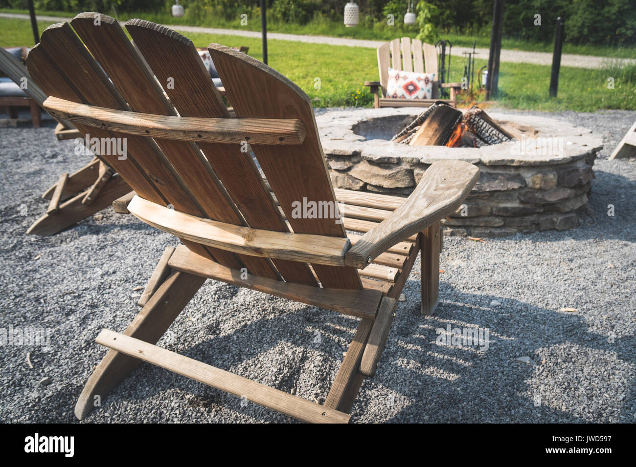 Wooden Adirondack Chair Next To A Fire Pit In The Woods Stock