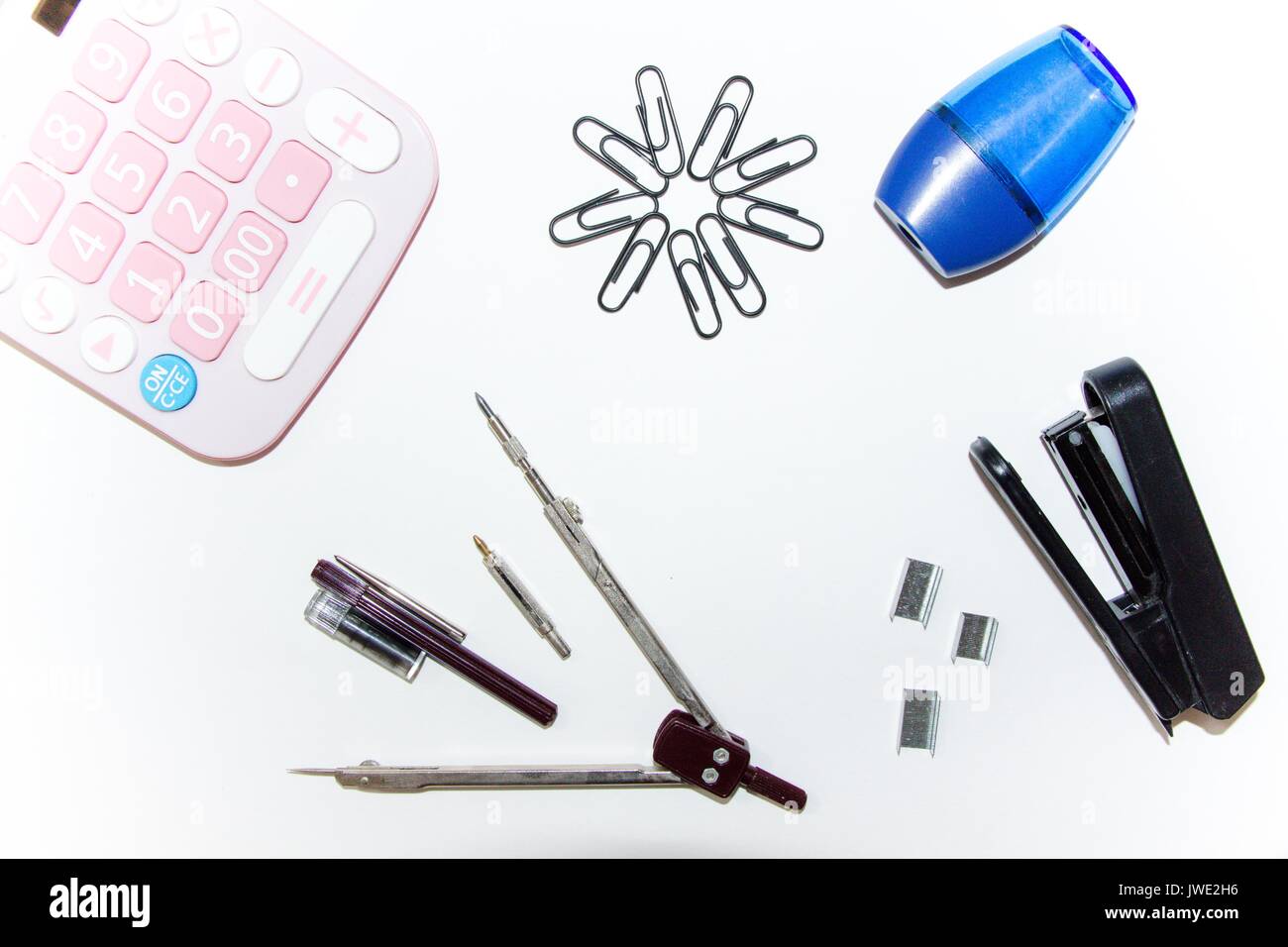 Accessories for the learning process-calculators, clips, compasses and accessories for the compass, stapler, staples, pencil sharpener. Stock Photo