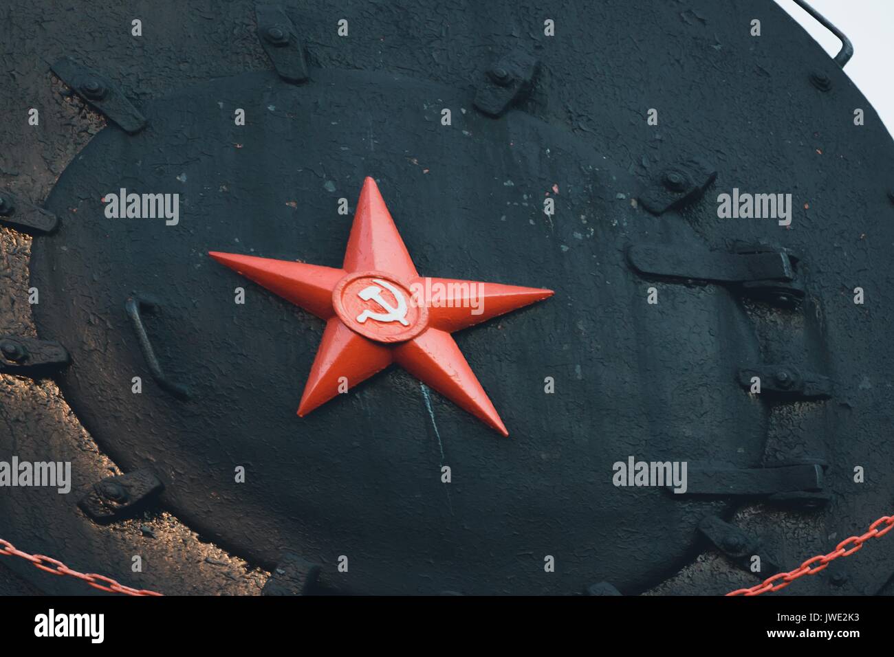 Red star is a symbol of the Soviet Union with a sickle and a hammer on a black metal background. Stock Photo