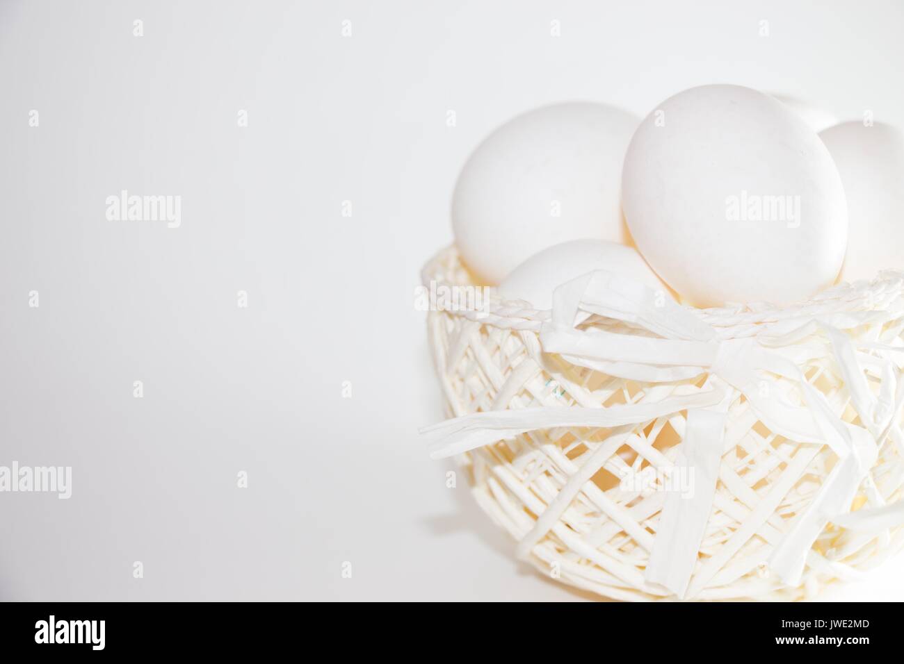 Chicken eggs in a white basket of jute cloth on a white background ...