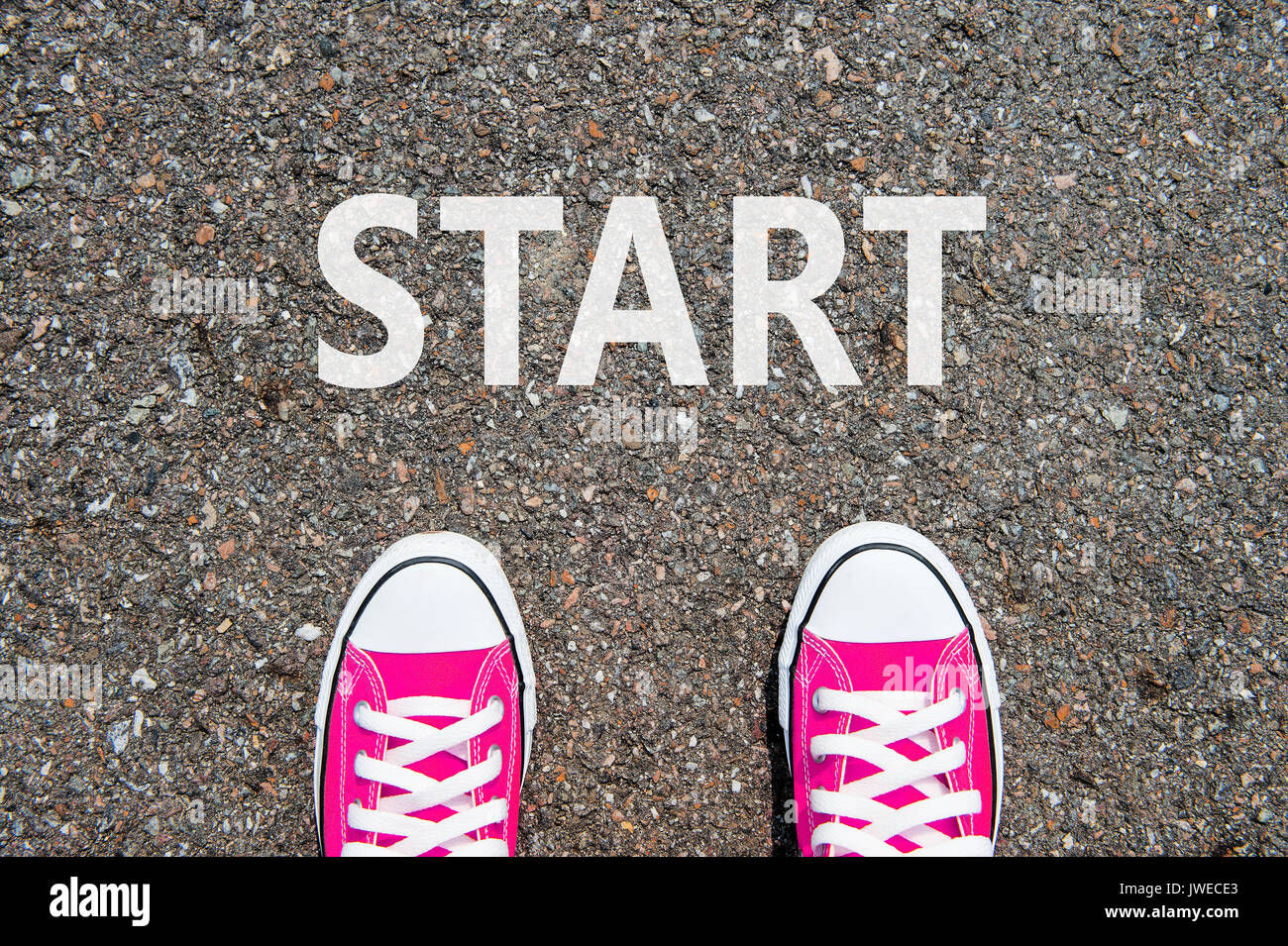 Feet concept with pink sneakers on black background with start text. Stock Photo