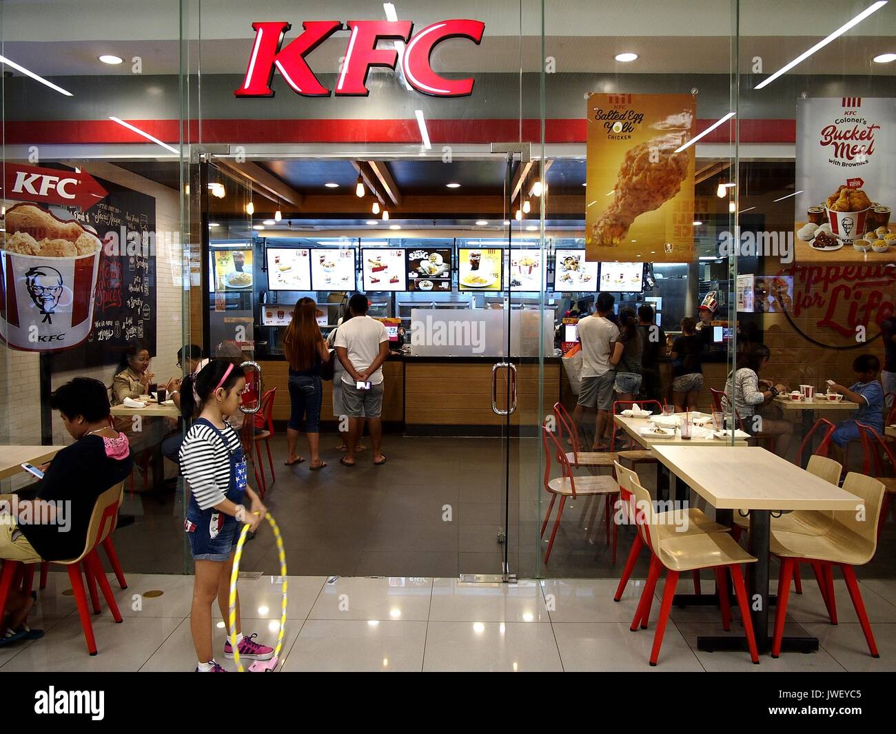 PASIG CITY, PHILIPPINES - AUGUST 6, 2017: Customers line up at the ordering counter of a Kentucky Fried Chicken or KFC branch in SM East Ortigas Mall. Stock Photo