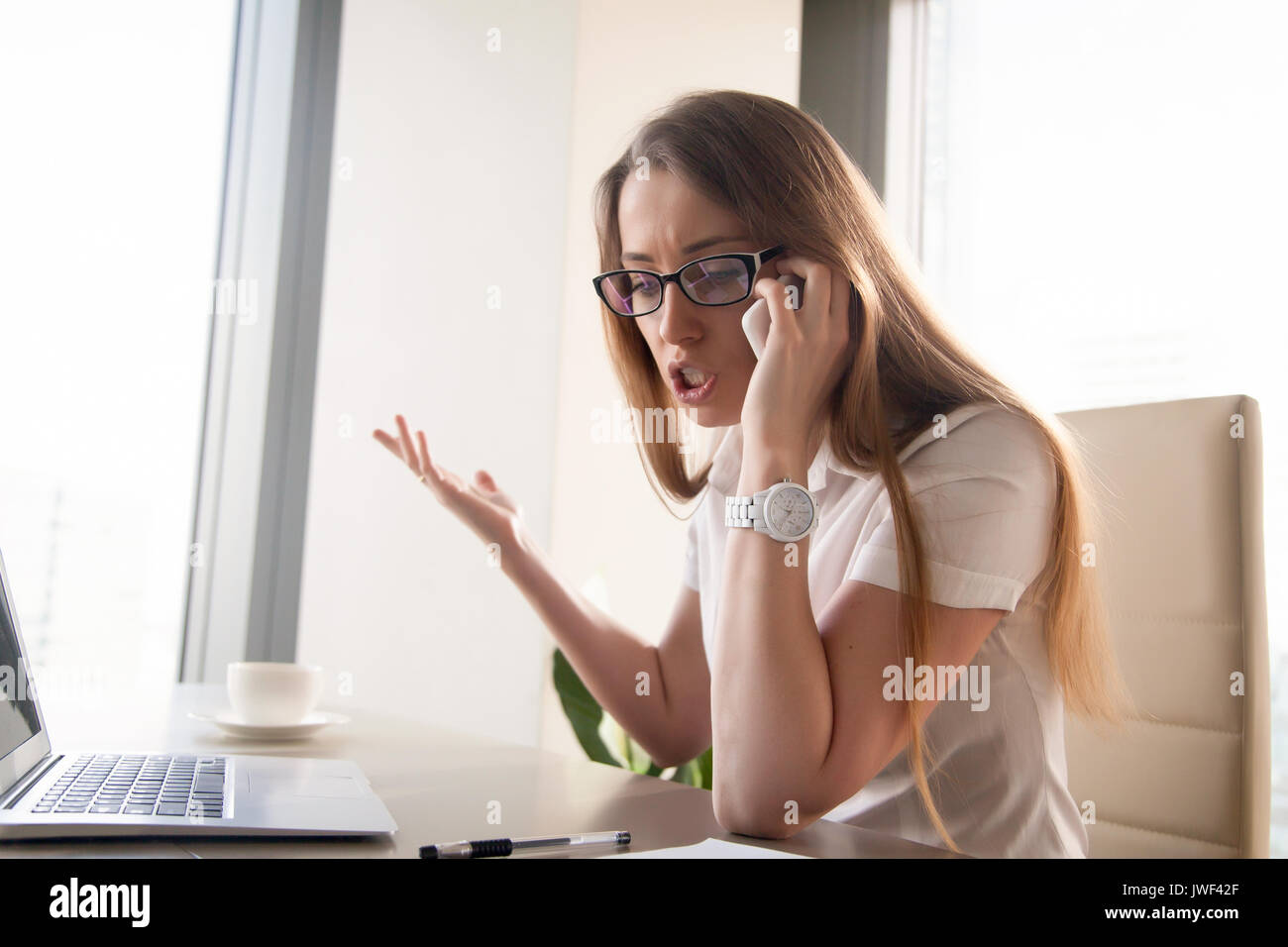 Angry confident businesswoman arguing shouting while talking on  Stock Photo