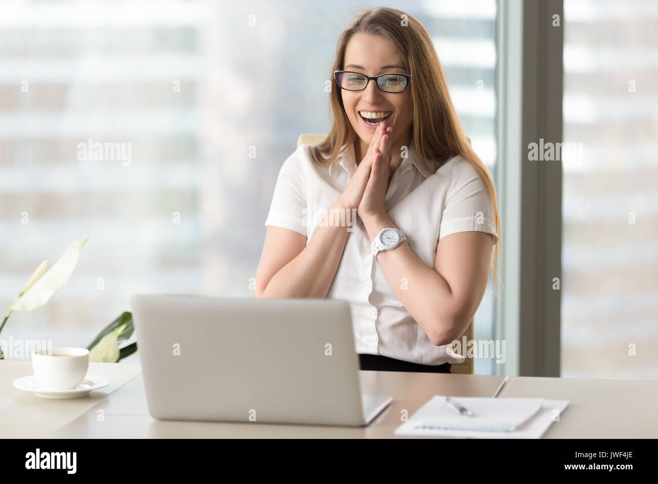 Happy businesswoman laughing with joy, gladly looking at laptop  Stock Photo