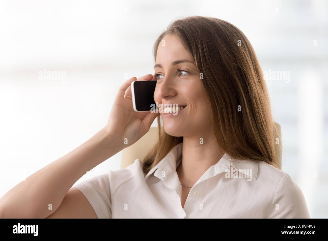 Smiling woman talking on the phone, making answering call, portr Stock Photo