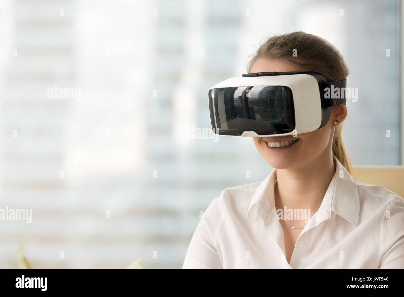 Happy woman wearing VR goggles, getting virtual ar reality exper Stock Photo