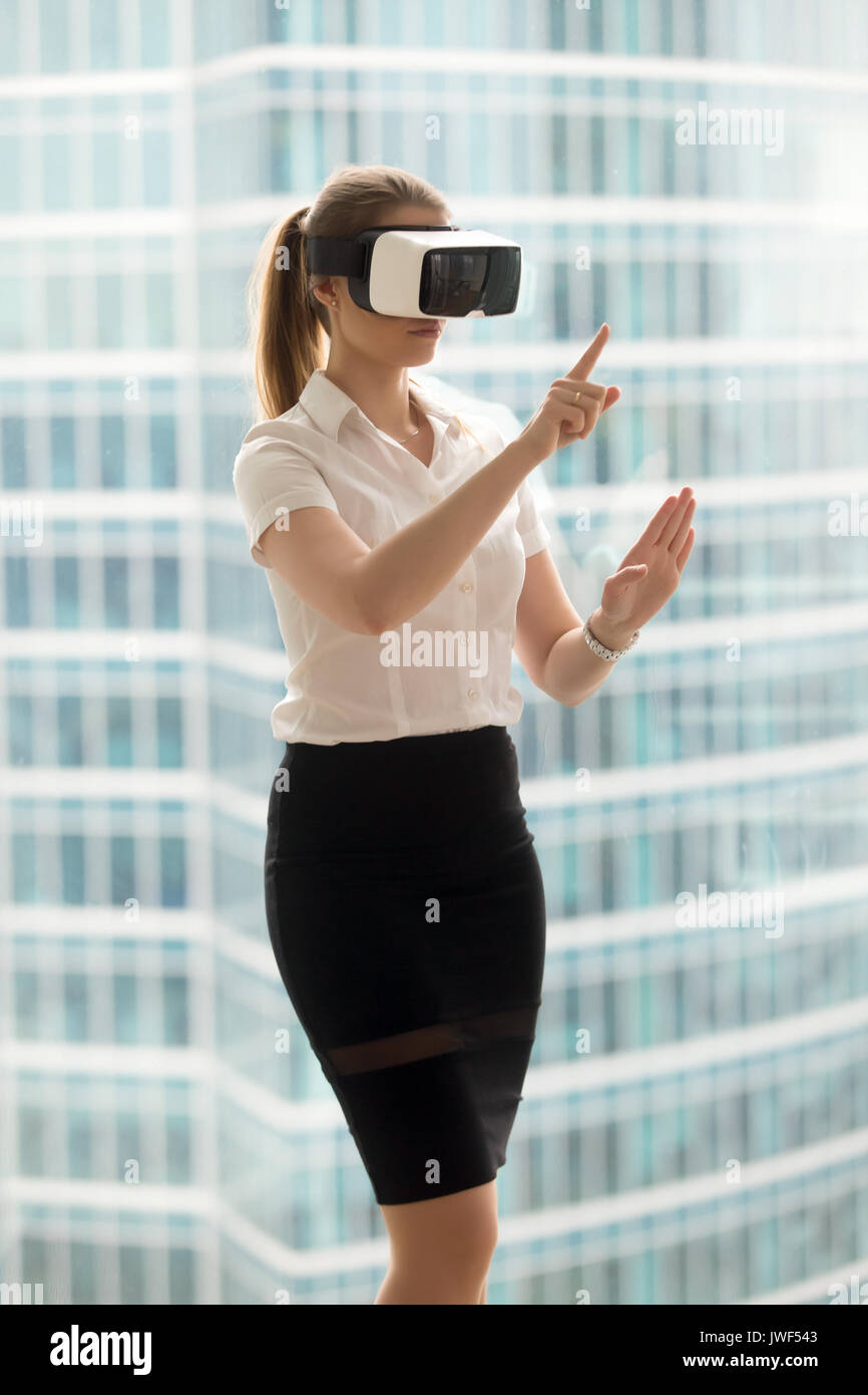 Serious businesswoman in VR headset trying virtual reality 3d to Stock Photo