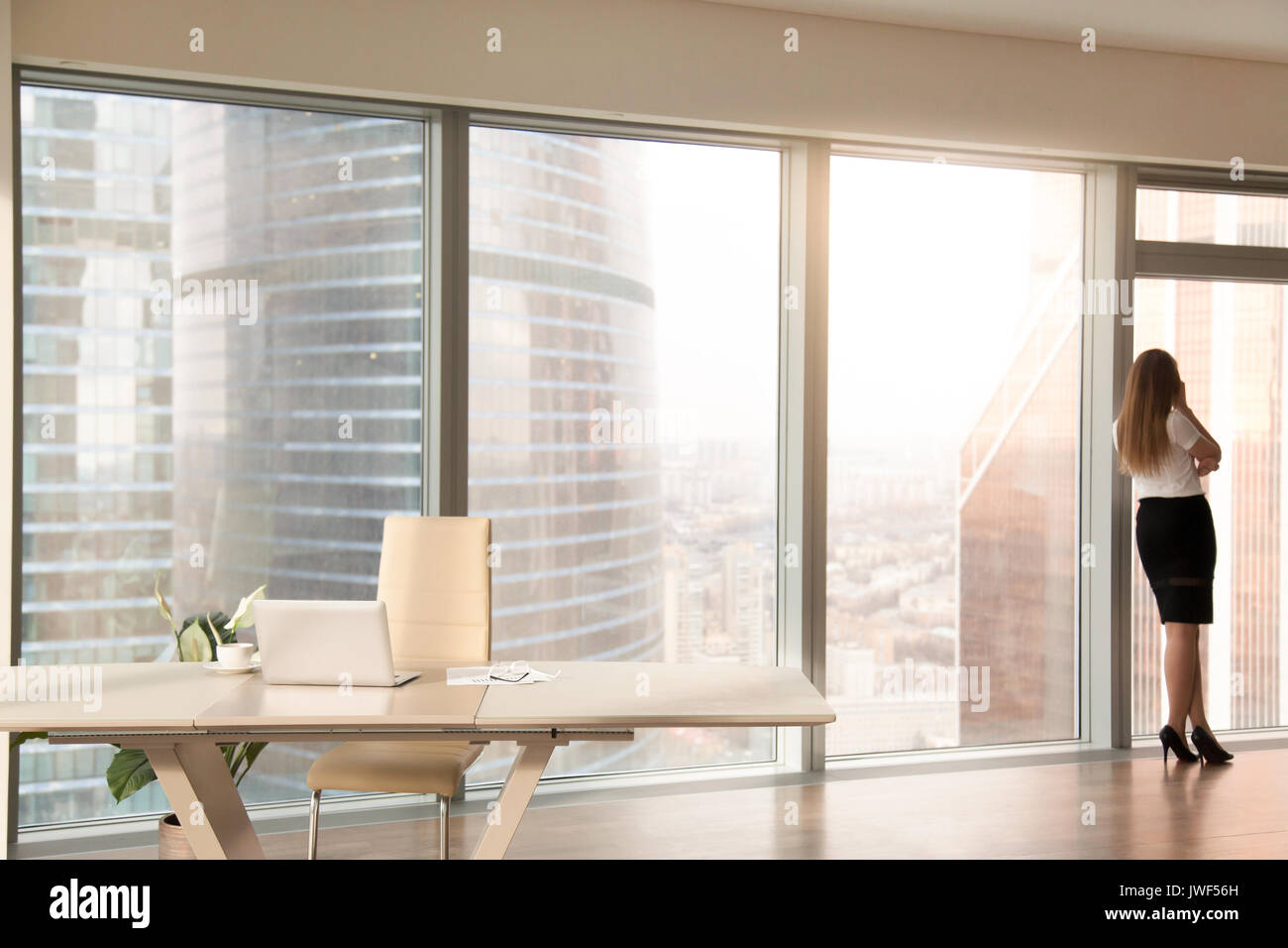 Modern office interior with female silhouette standing at full-l Stock Photo