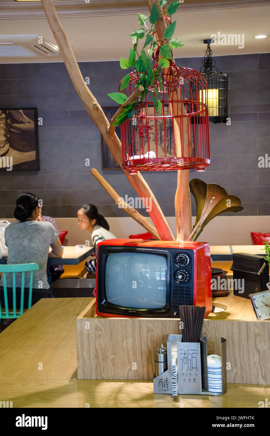 An old TV and a bird cage arranged as a centerpiece in a restaurant in
