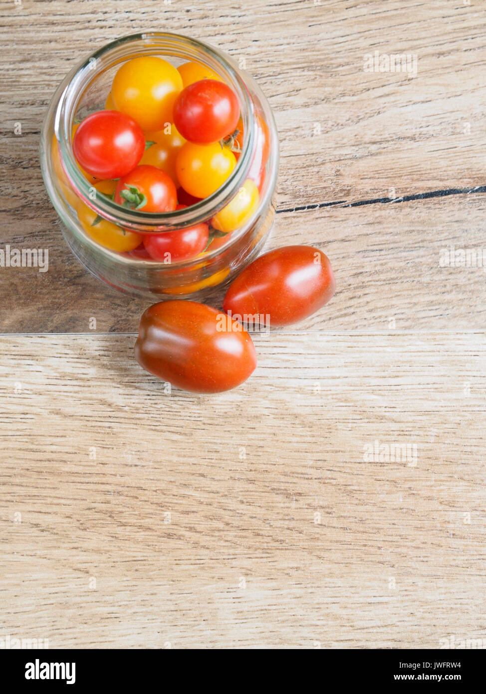 Cherry tomatoes background in a glass jar Stock Photo - Alamy