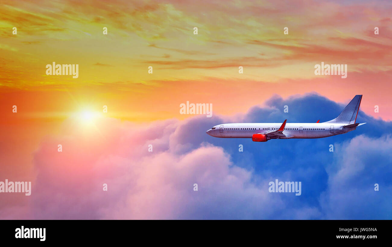 Airplane flying above clouds in sunset light Stock Photo - Alamy