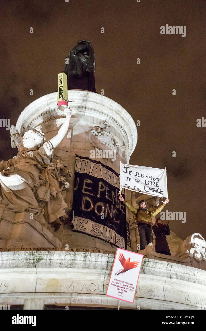 A big pencil and a man with a banner. Homage at the victims of Charlie hebdo killing in Paris the 7th of january 2015. Stock Photo