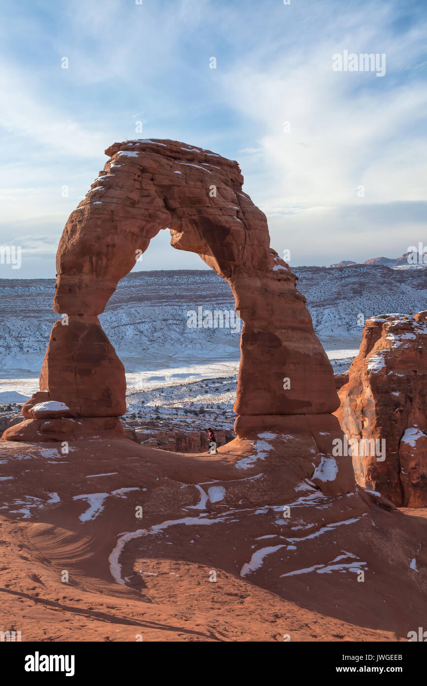 A woman was walking under the Delicate Arch at Arches National Park, Moab, Utah, on a winter morning Stock Photo