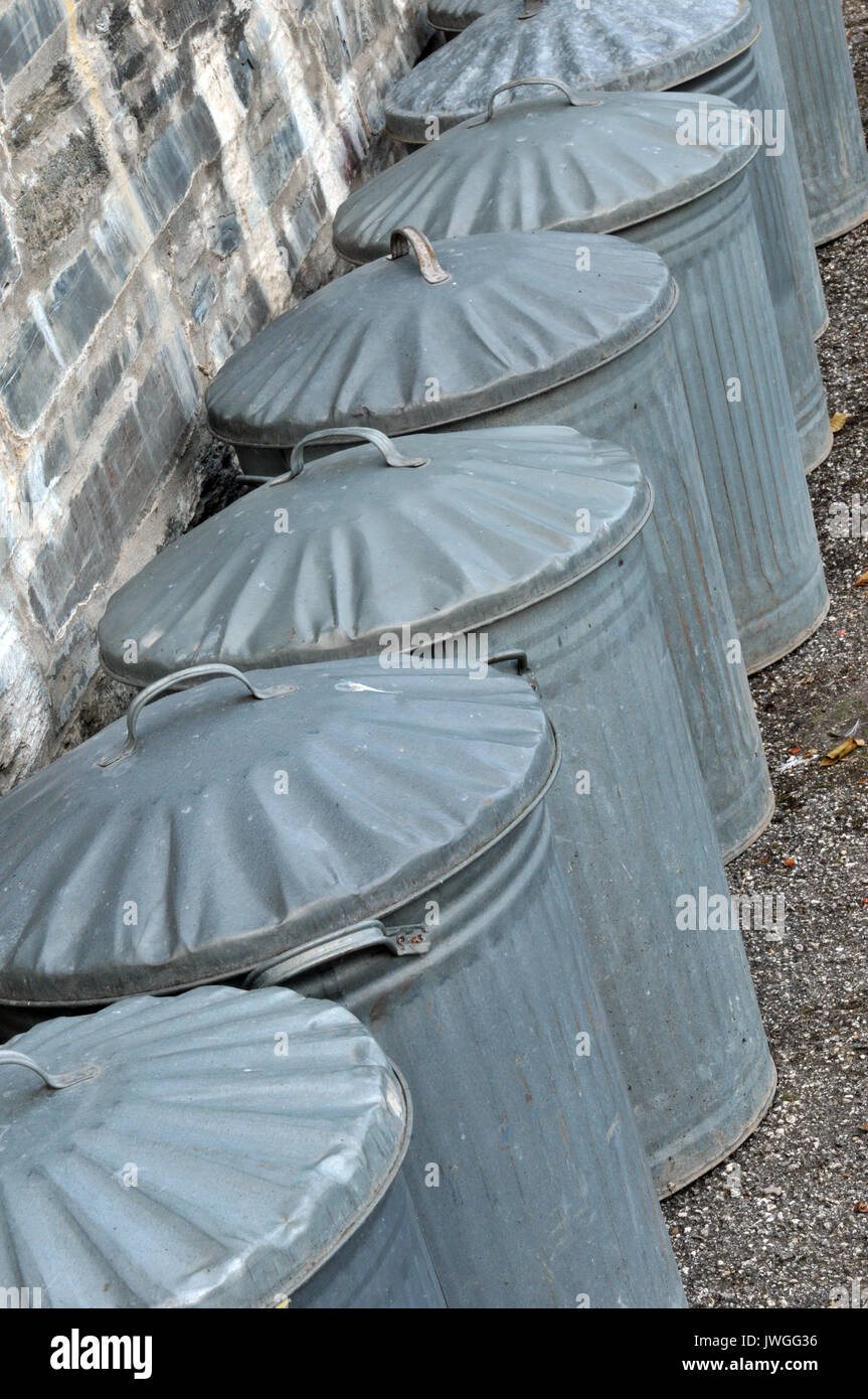 some galvanizes steel dustbins in a row garbage trash bin collections refuse collections local authorities traditional metal dustbins in a row lids on Stock Photo