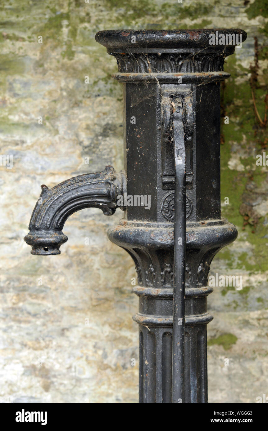 a Victorian or old fashioned antique or vintage water pumping station or water pump. Drawing water from a well using a hand operated pump with handle. Stock Photo