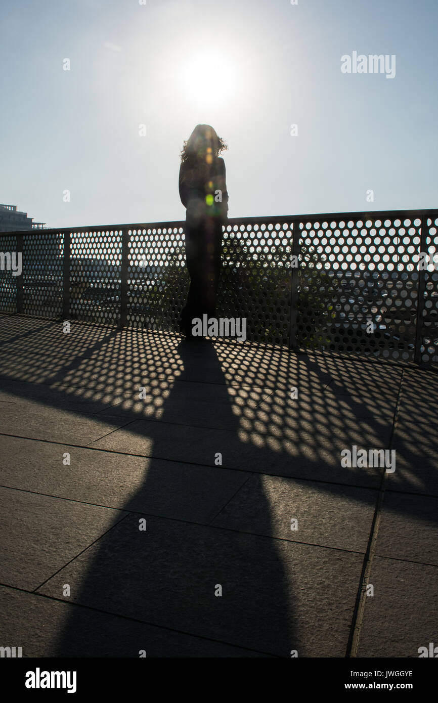Rear view silhouette of a young woman standing outdoors Stock Photo - Alamy