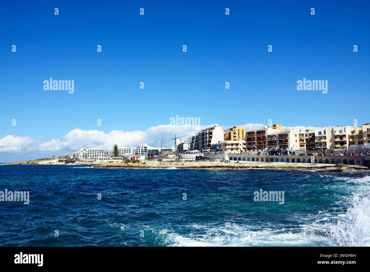 View of the rocky coastline with hotels and apartments to the rear, Bugibba, Malta, Europe. Stock Photo