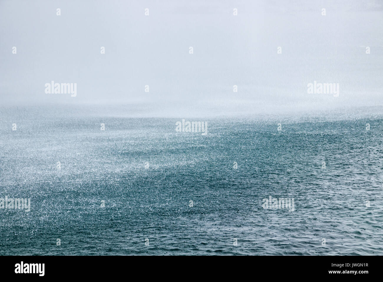 Heavy rainfall on a water surface. Stock Photo