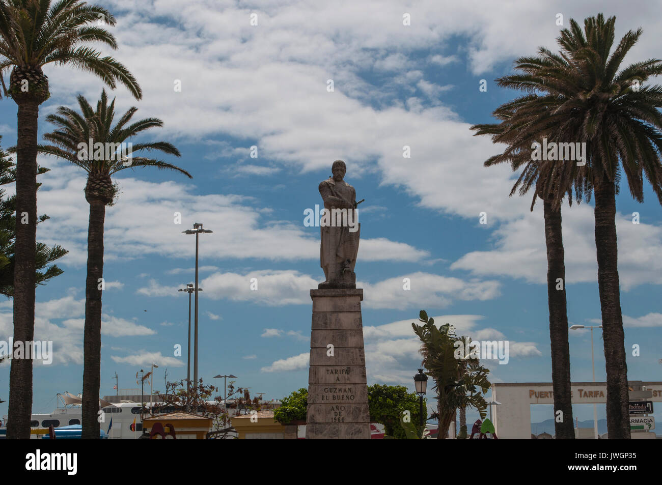 clouds, palm trees and the statue of Guzman El Bueno, Spanish nobleman and hero of Spain during the medieval period in the town of Tarifa Stock Photo