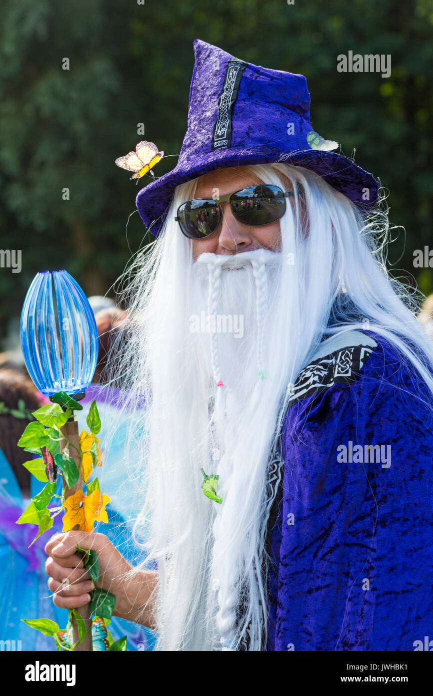 Burley, Hampshire, UK. 12th Aug, 2017. New Forest Fairy Festival. Masses of fairies and elves, sprinkled with fairy dust, descend on Burley for the weekend for a magical enchanting festival in the New Forest. Man dressed as Wizard in robe and hat with long white hair and beard holding stave. Credit: Carolyn Jenkins/Alamy Live News Stock Photo