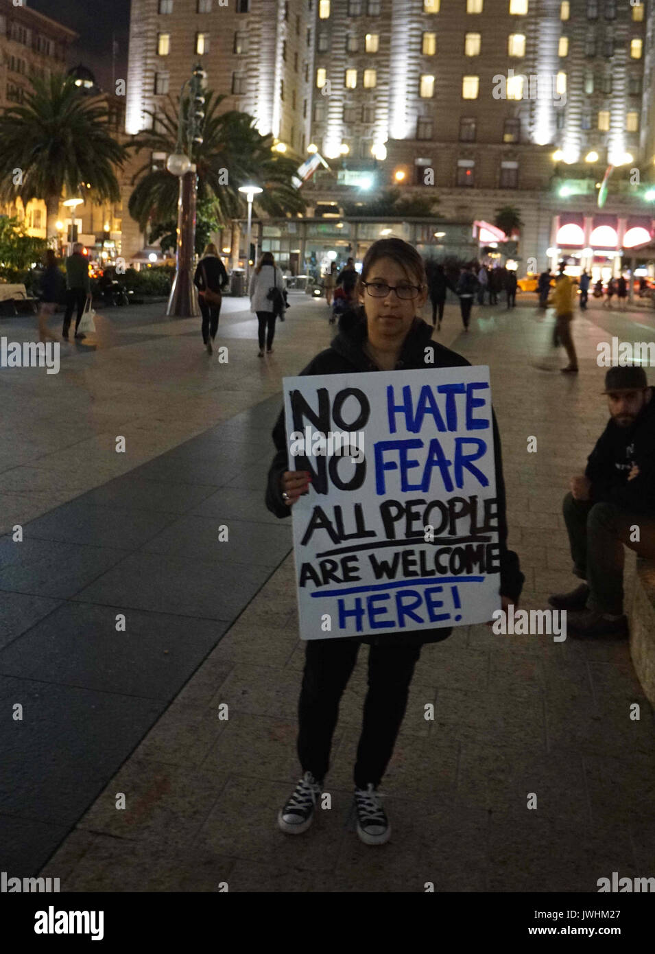 San Francisco, USA. 12th Aug, 2017. A woman holding a sign reads 'No Hate No Fear All People Are Welcome Here' take part in a candle light vigil in downtown San Francisco, the United States, on August 12, 2017. Three people were killed and 19 wounded in Charlottesville, as a supporter of the so-called alt-right movement rammed his car into a crowd of protesters against a white nationalist rally. Then, a local group known as Indivisible SF, short for San Francisco, called for the vigil 'to stand in solidarity with Charlottesville.' Credit: Xu Yong/Xinhua/Alamy Live News Stock Photo