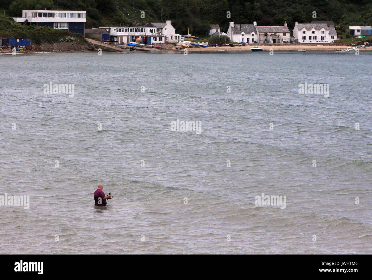 Jill Saward's husband Gavin scatters her ashes in the sea off Nefyn beach in Gwynedd, north-west Wales following a memorial service for the victims' rights campaigner. Stock Photo