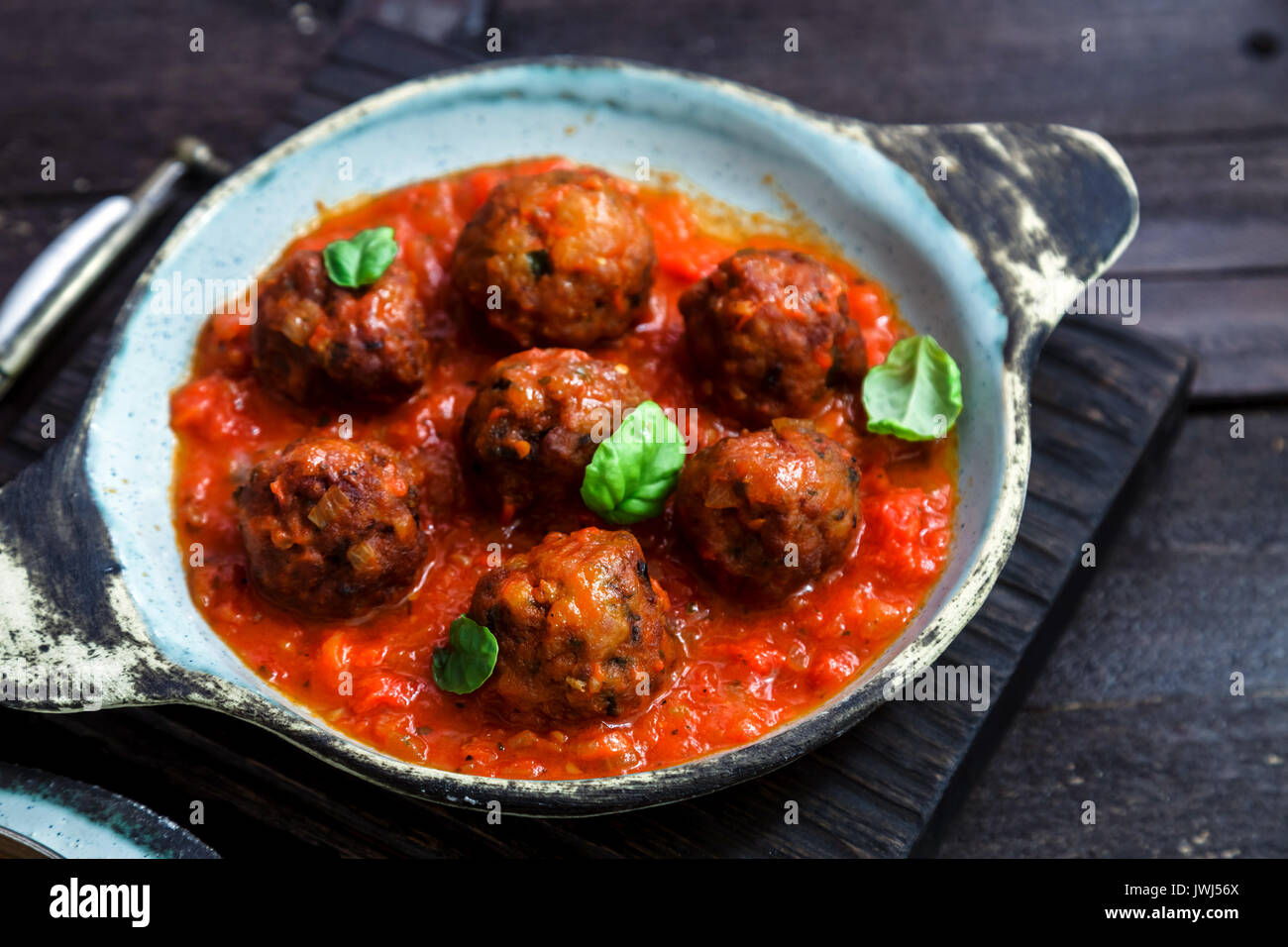 Meatballs with tomato sauce on a ceramic pan. Close view, rustic style Stock Photo