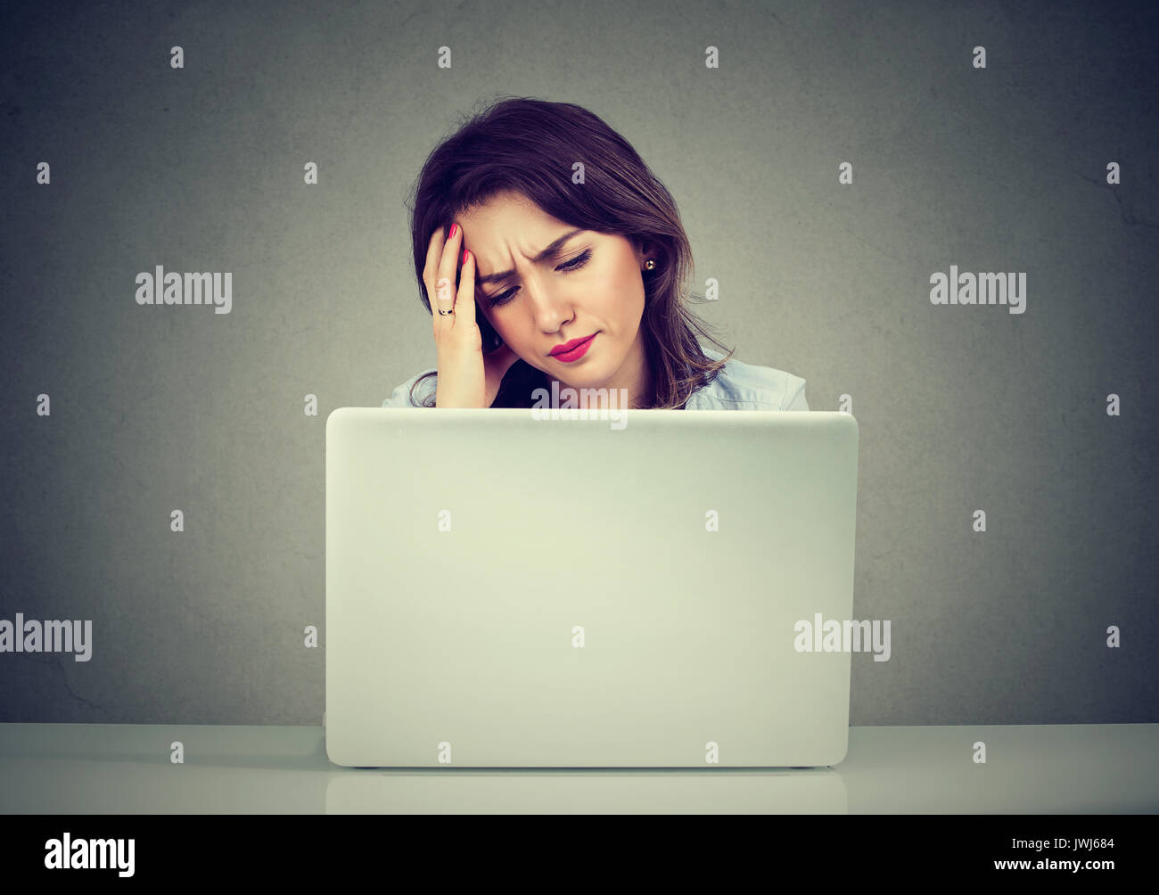 stressed business woman looking at her laptop Stock Photo